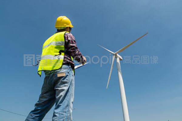 电动工程师用风力涡轮机在剪贴板上写报告